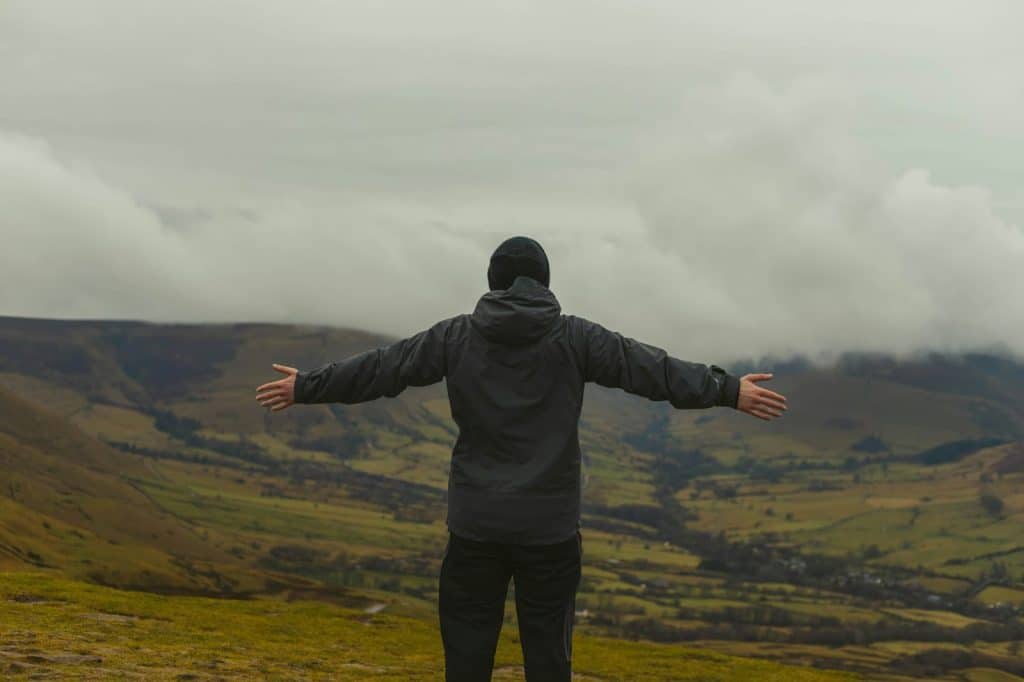A man spreading his arms with a nice view