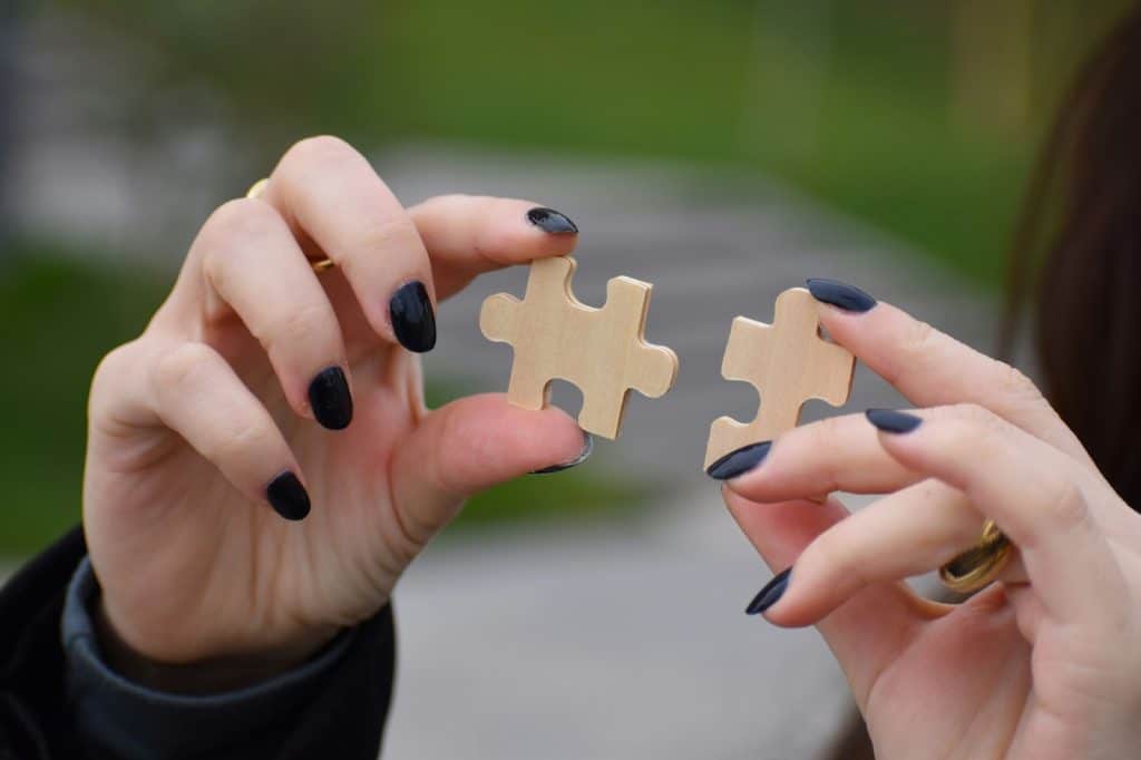 A woman hold two puzzle pieces together