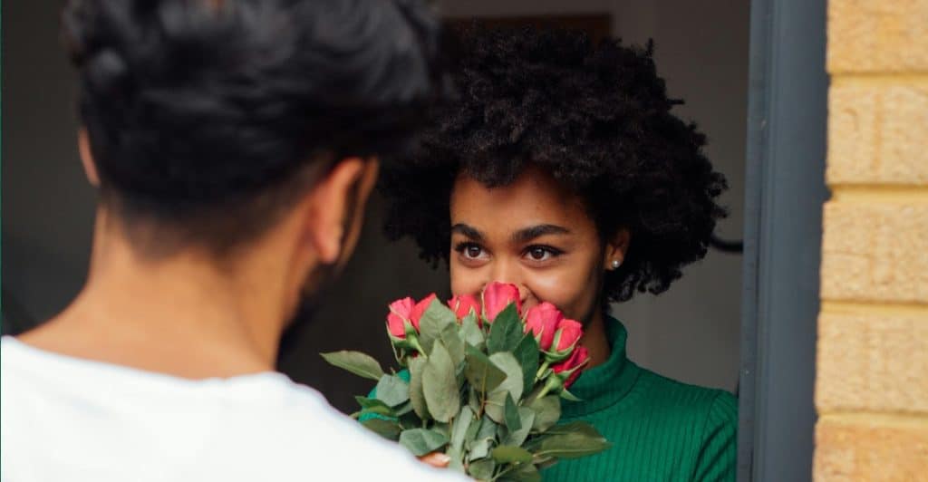 A man giving flowers to a woman working through a disagreement showing composure during conflict.