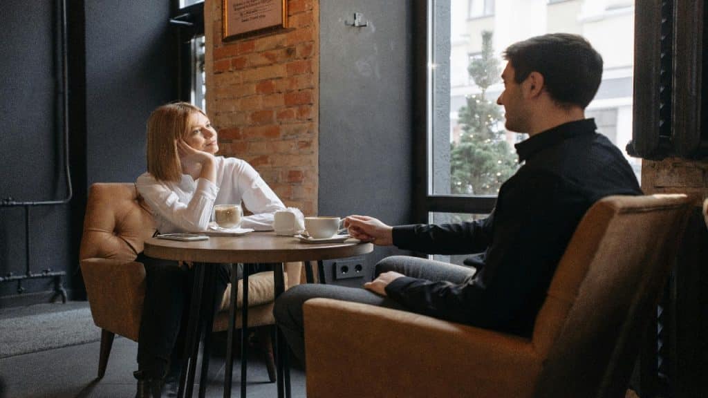 A couple leaning in with curiosity and attentiveness during a relaxed conversation.