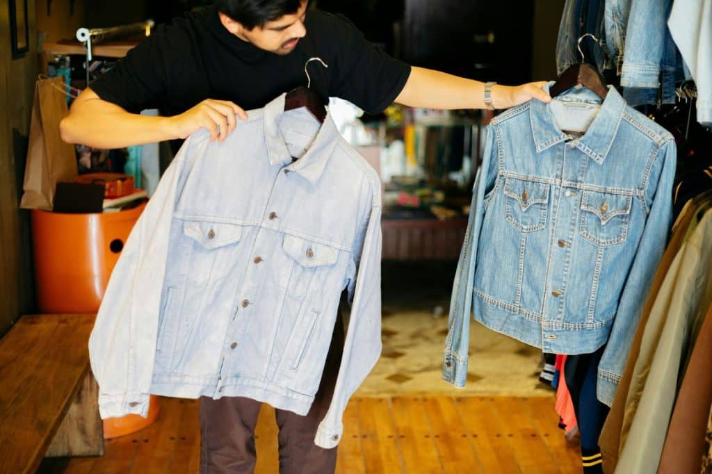 A man comparing two cardigan jackets.