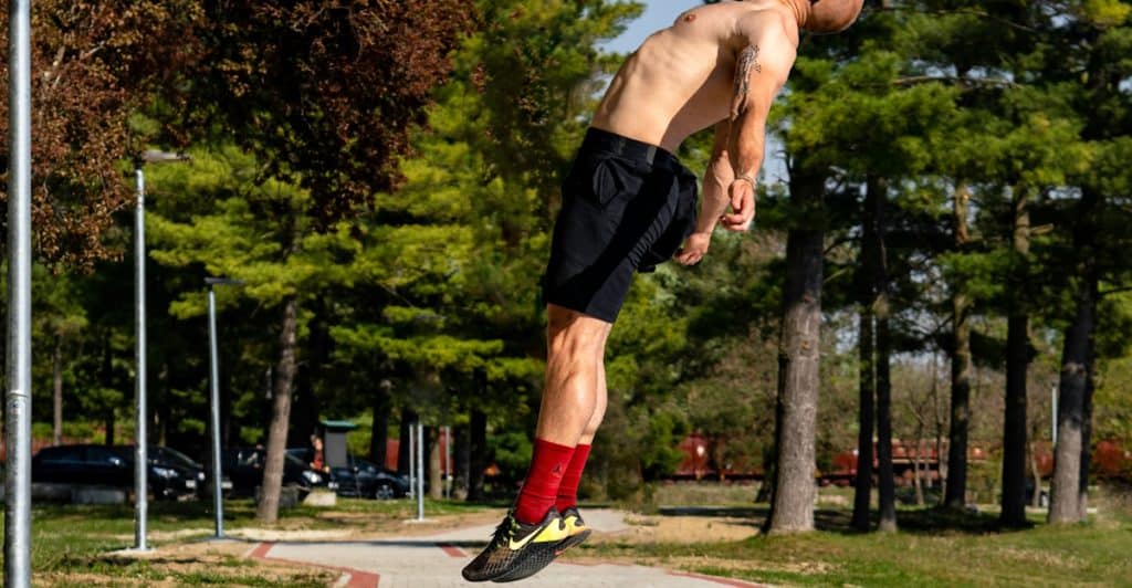 A Shirtless Man jumping vertically.