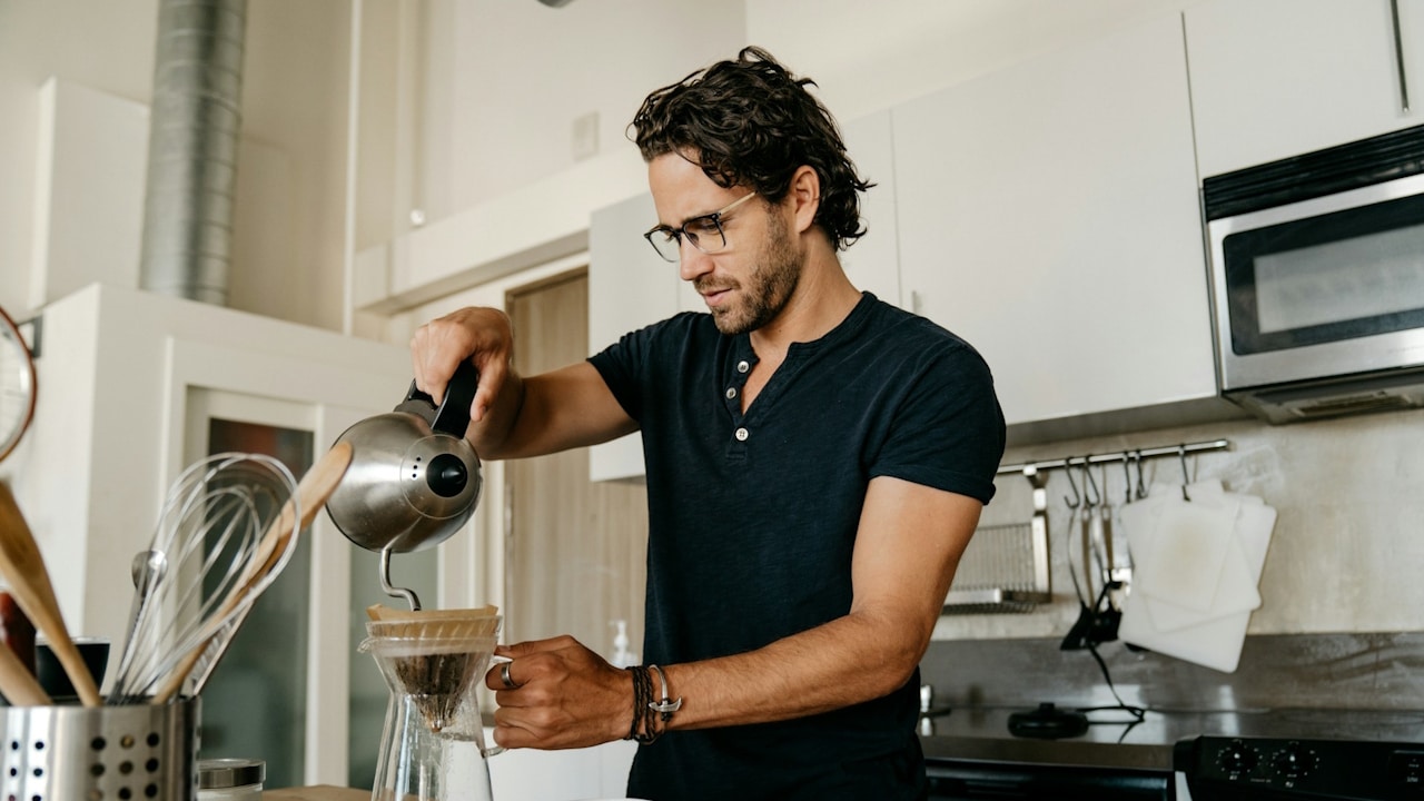 A man preparing his coffee alone.