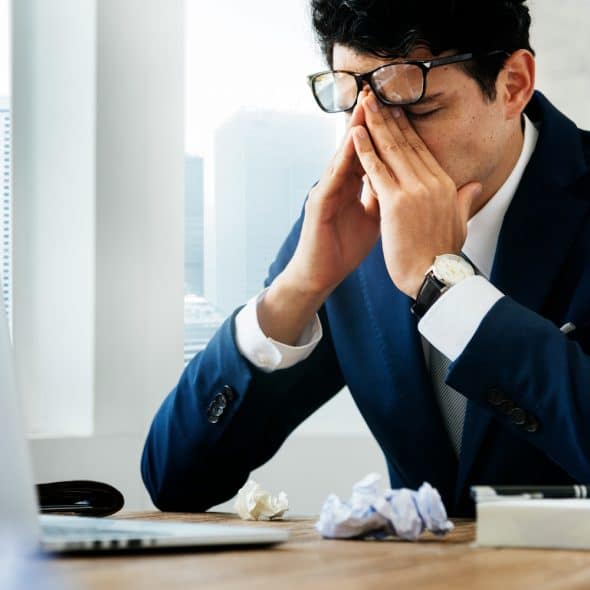 A man looking frustrated at work.