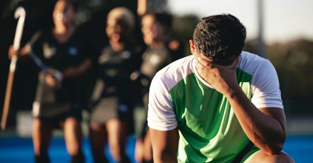 A man losing a field hockey match.