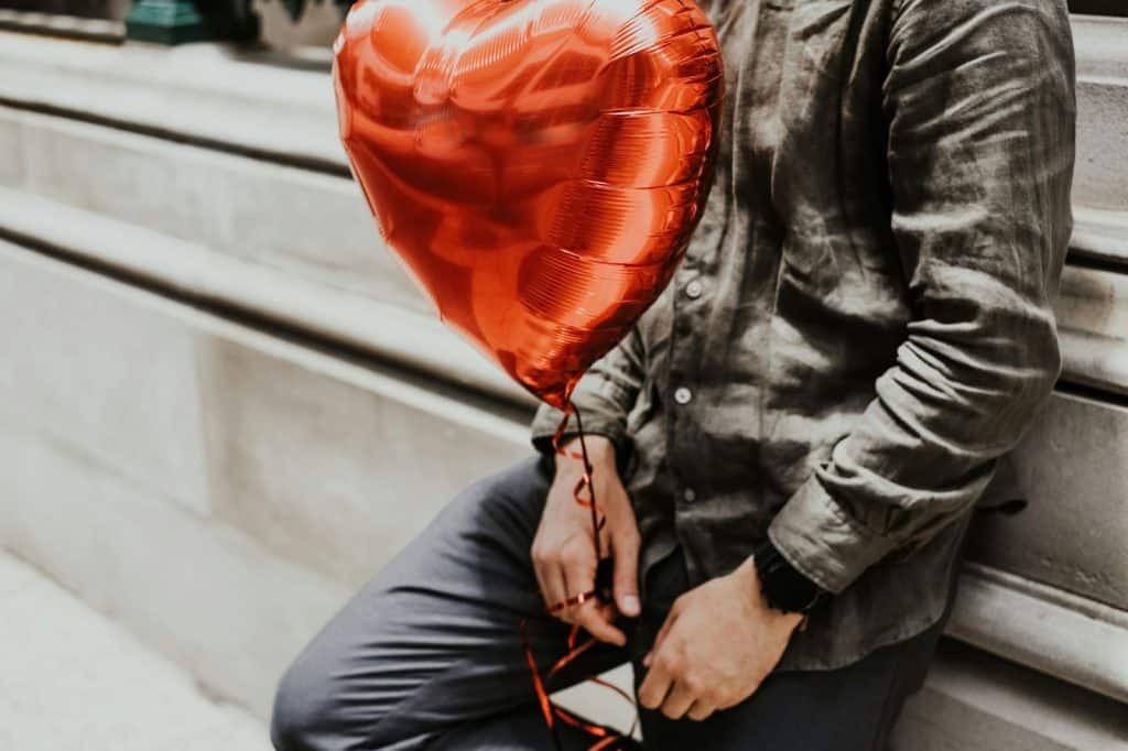 A man holding a heart balloon.
