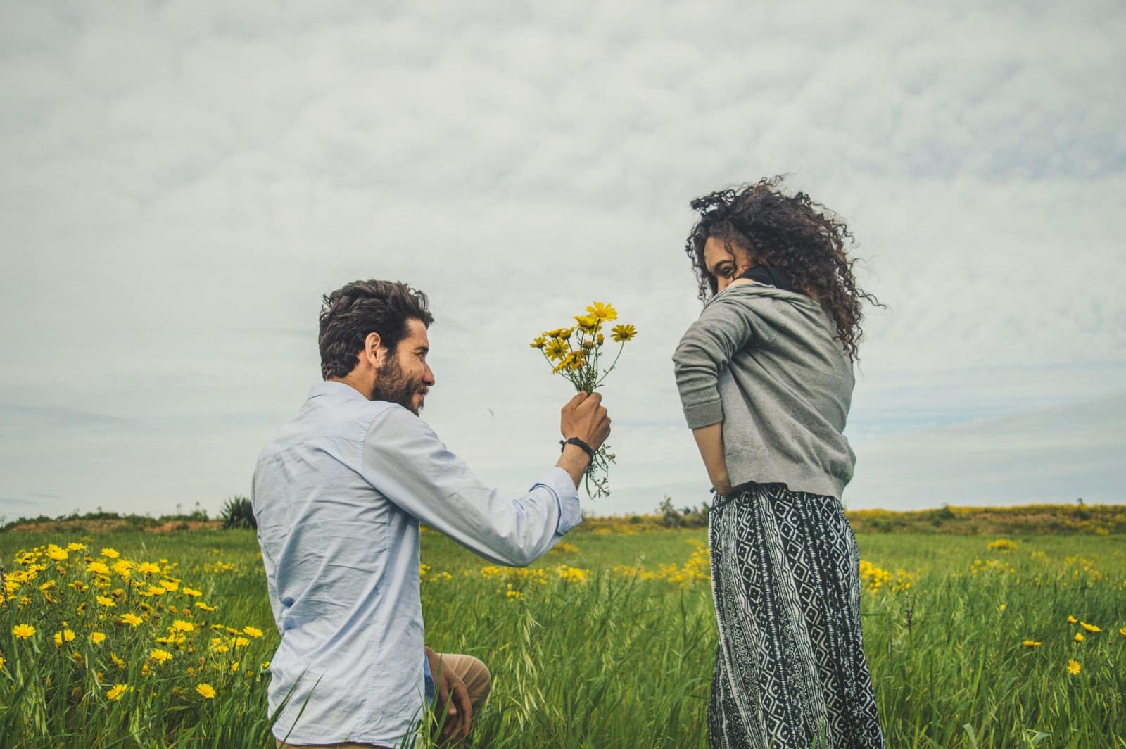 A man kneeling to a woman.