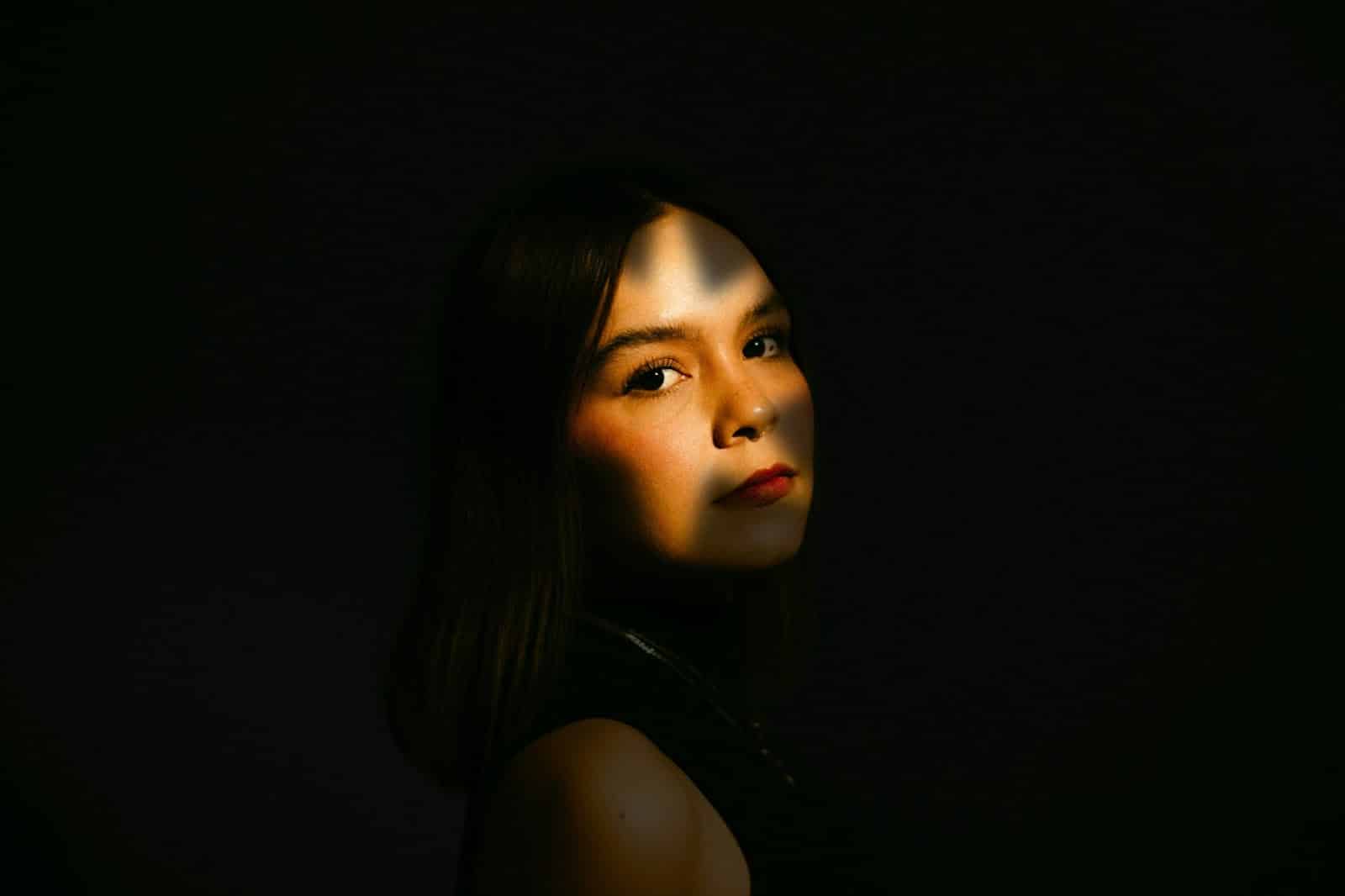 A woman posing in a dark place.