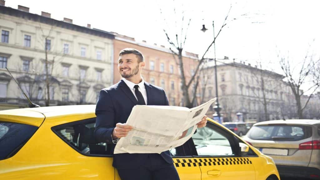 A man holding a newspaper in the street