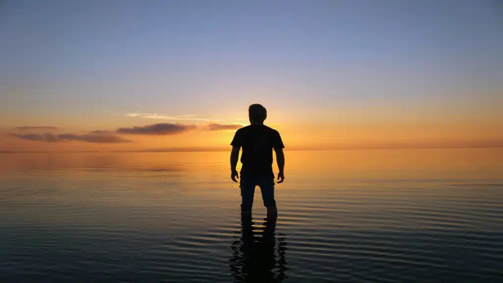 A man’s silhouette by the beach at sunset