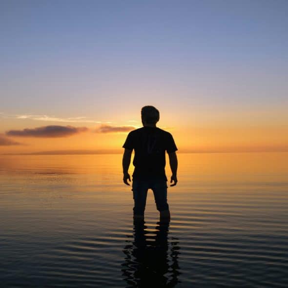 A man’s silhouette by the beach at sunset