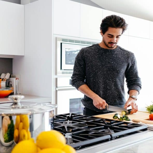 A man cutting vegetables in the kitchen