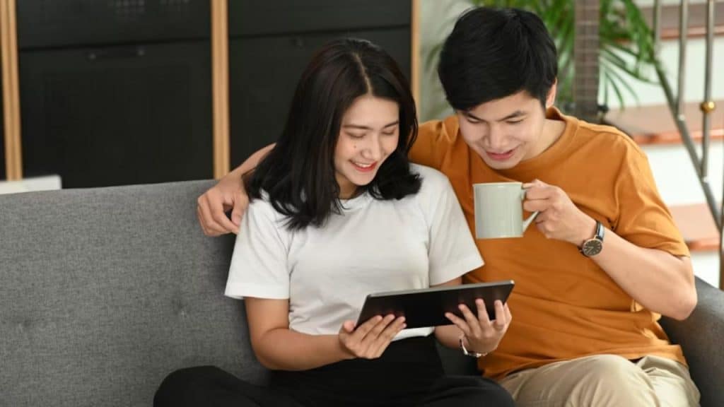 Couple reviewing a shared life goals list with a tablet.