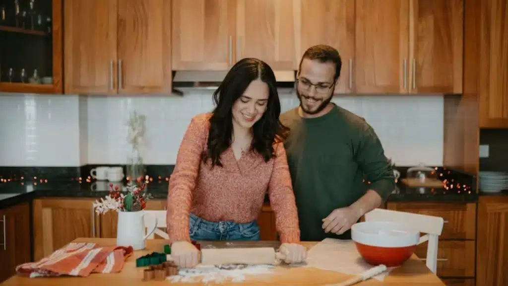 Couple smiling while trying to make pasta at home for the first time