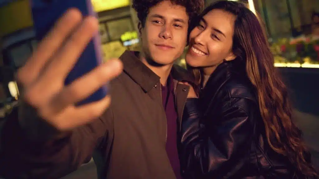 Couple smiling as they revisit their first date spot and capture the moment
