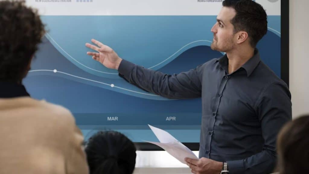 Man standing confidently and offering a solution on a whiteboard during a meeting