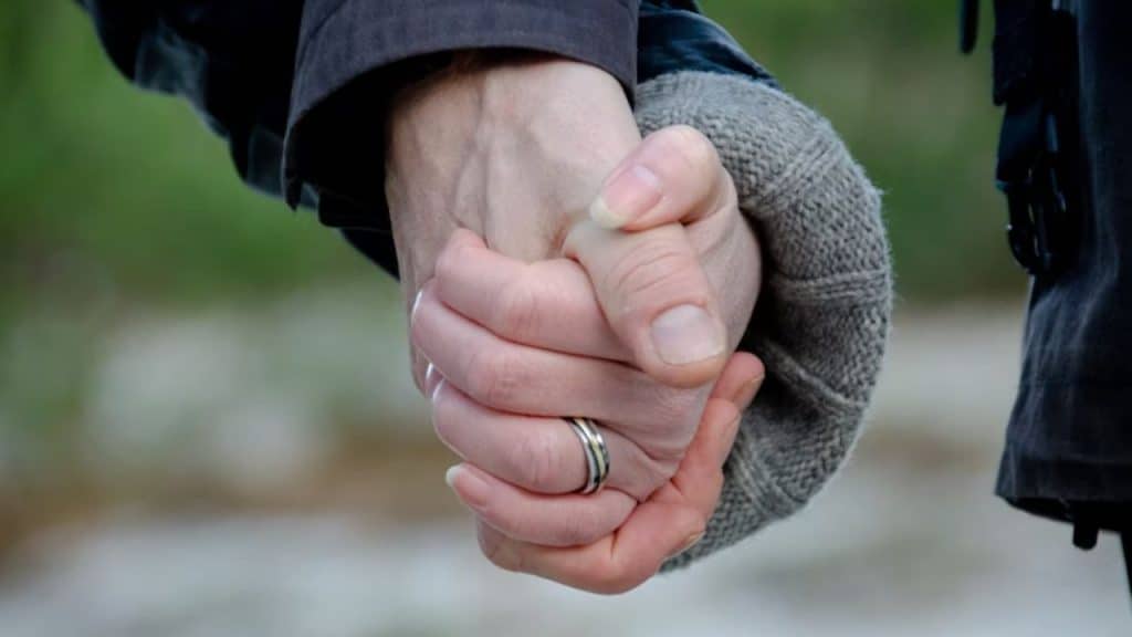 Man holding his partner’s hand during a quiet, emotional moment