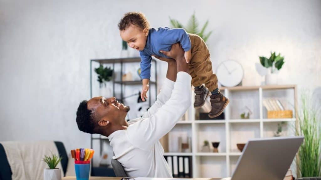 Man balancing work and parenting responsibilities in a home environment
