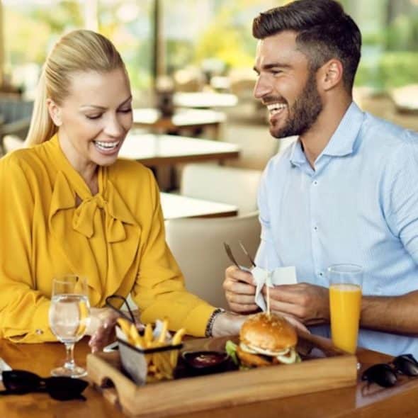 Man smiling while passionately discussing his hobby during a dinner date