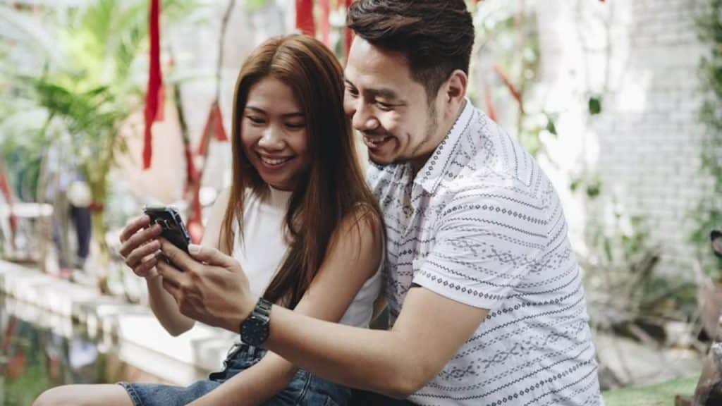 Man showing a family photo on his phone while smiling