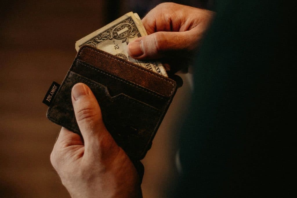 A man getting money from his wallet.
