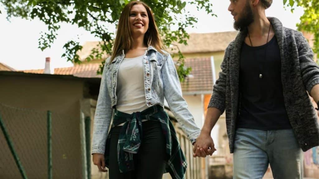 Happy couple walking together outdoors after connecting online.