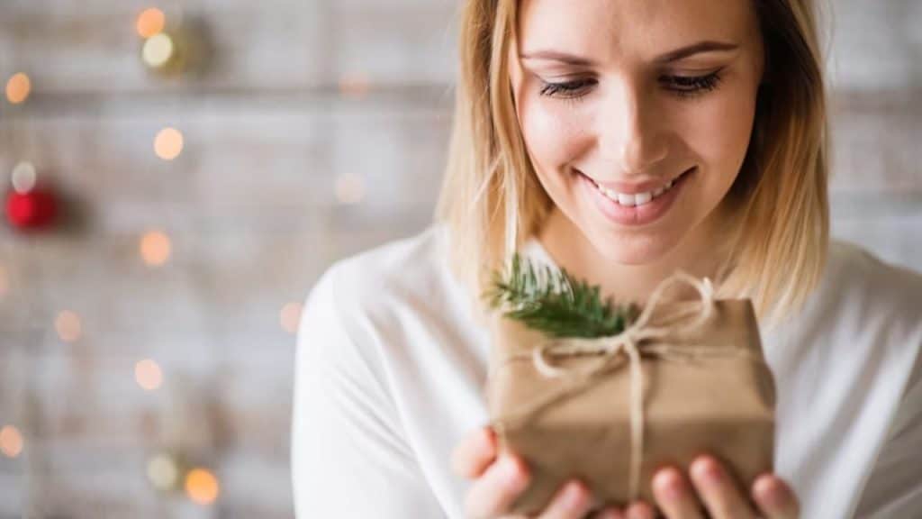 Woman excitedly holding a gift after the scavenger hunt trail for their anniversary.