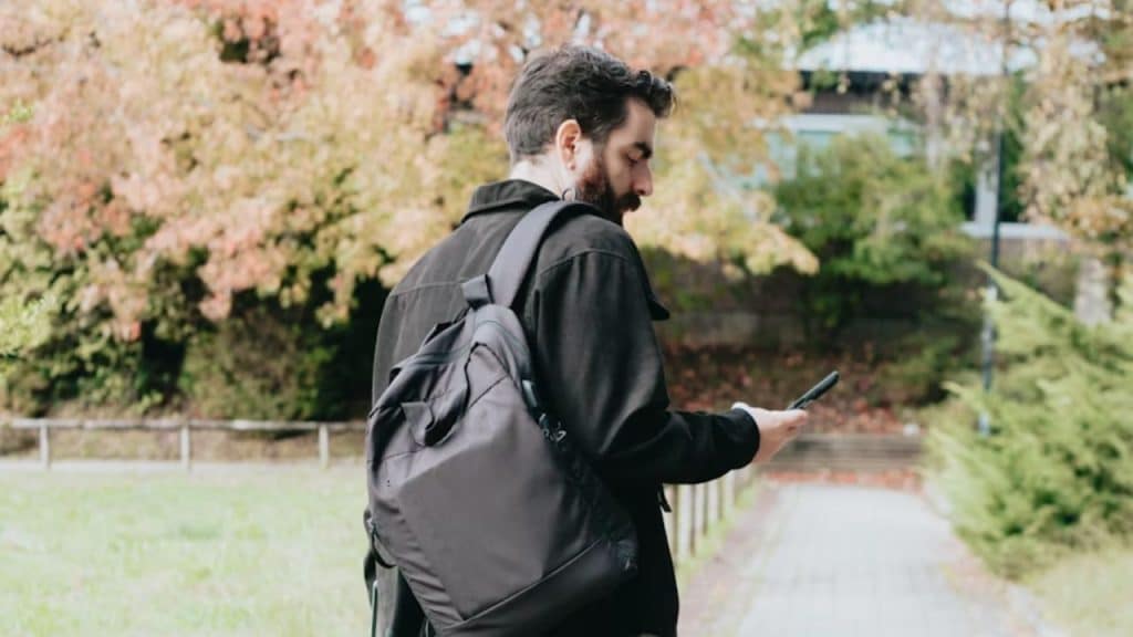 Man putting his phone on silent during a walk.