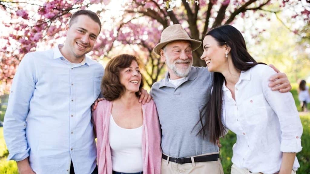 A man enjoying the moment with his parents and partner.