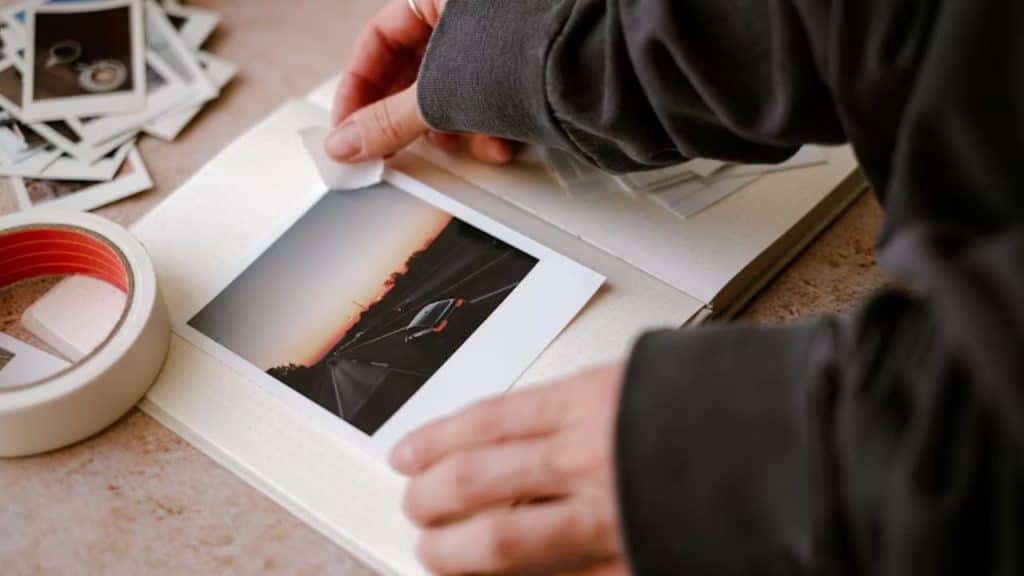 Man creating a handmade photo book filled with shared memories for his partner.