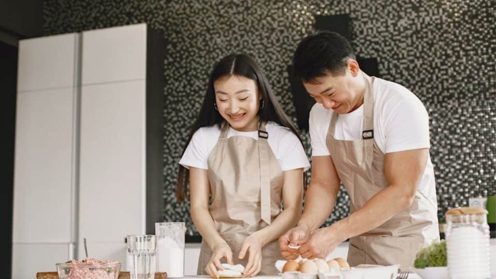 Couple enjoying a hands on cooking class together as a romantic, interactive gift.