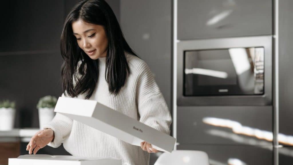 Woman unboxing a subscription box tailored to her personal interests and hobbies.