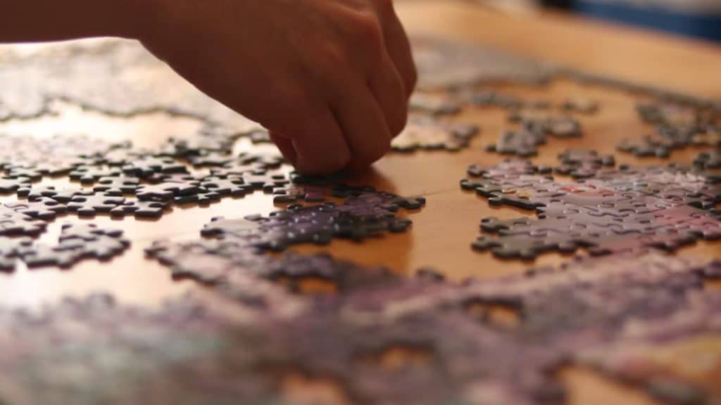 Couple assembling a photo puzzle of a travel memory on a cozy table.