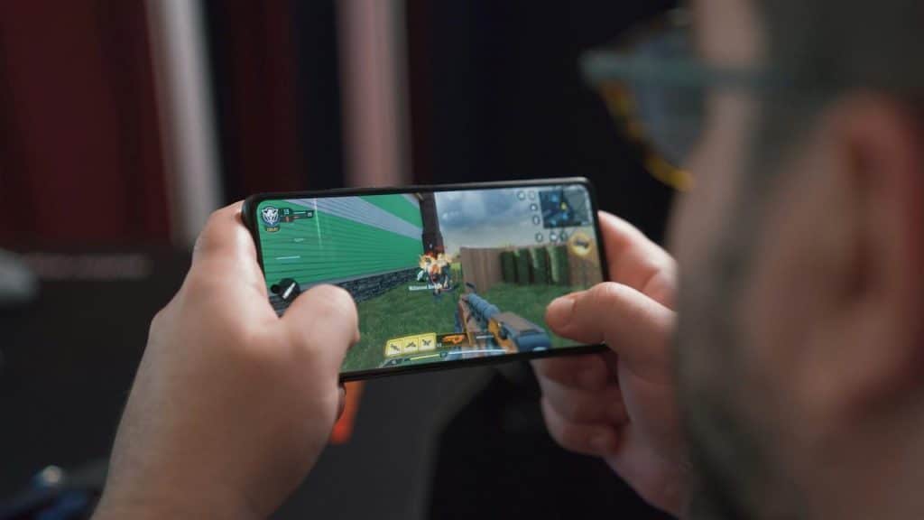 A person playing a first-person shooter game on a smartphone.