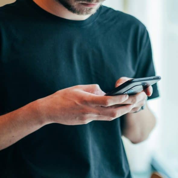 A man in a black shirt texting