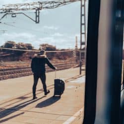 A man with a suitcase on a train platform