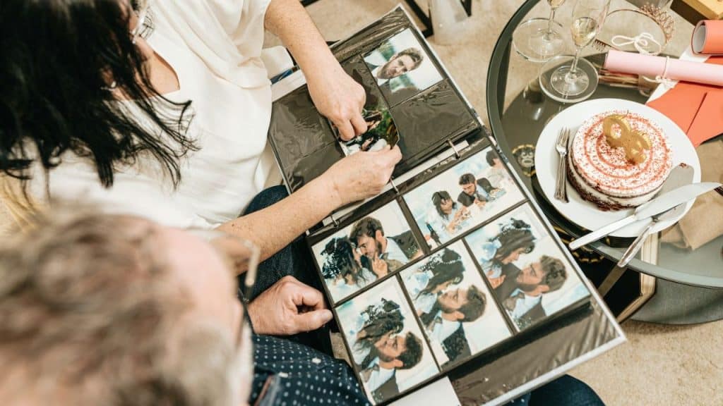 A person points at photos in an album held by another person.