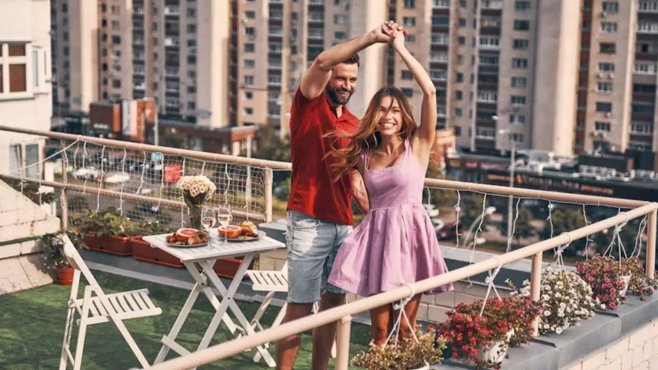 A confident man dancing calmly with his partner on a rooftop.