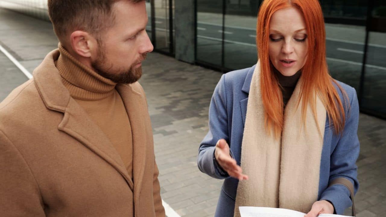 Woman nervously over explaining a simple topic while man listens quietly.