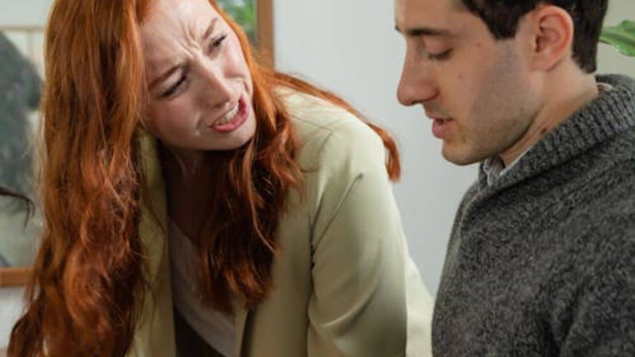 Woman echoing a question during a conversation while the man observes her reaction.