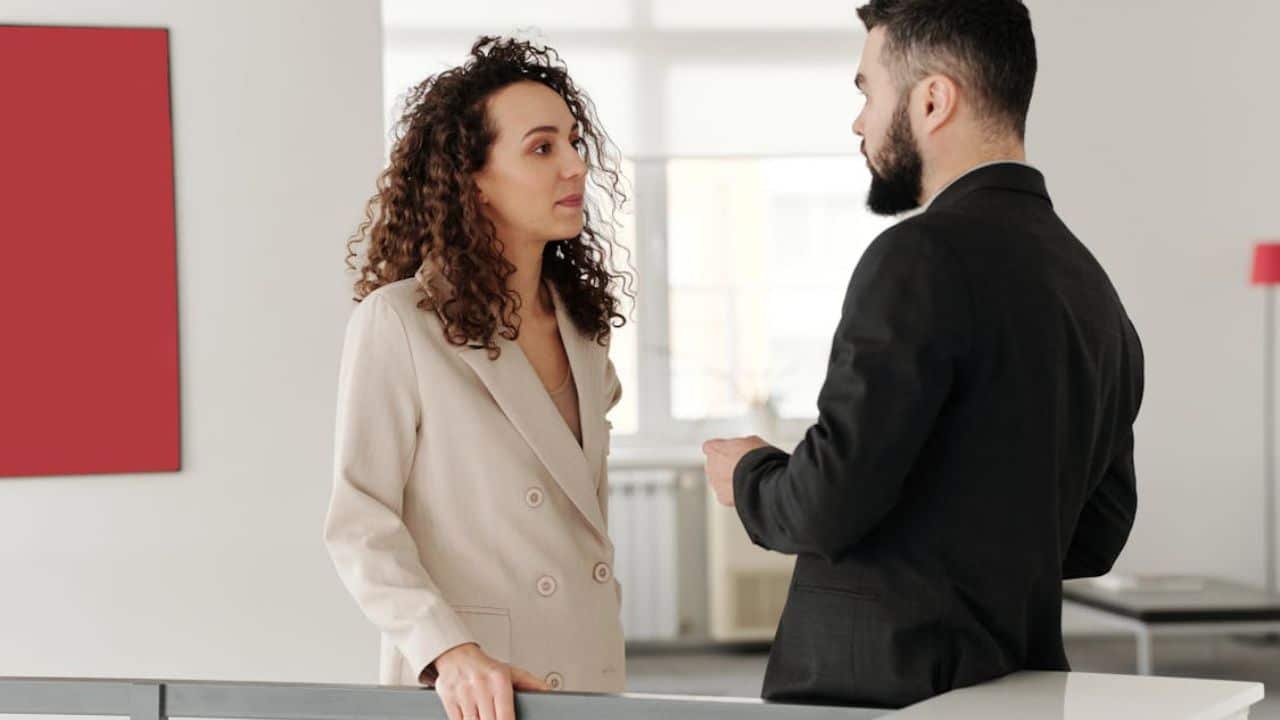 Woman reacting strongly to a simple question, man watching with concern.