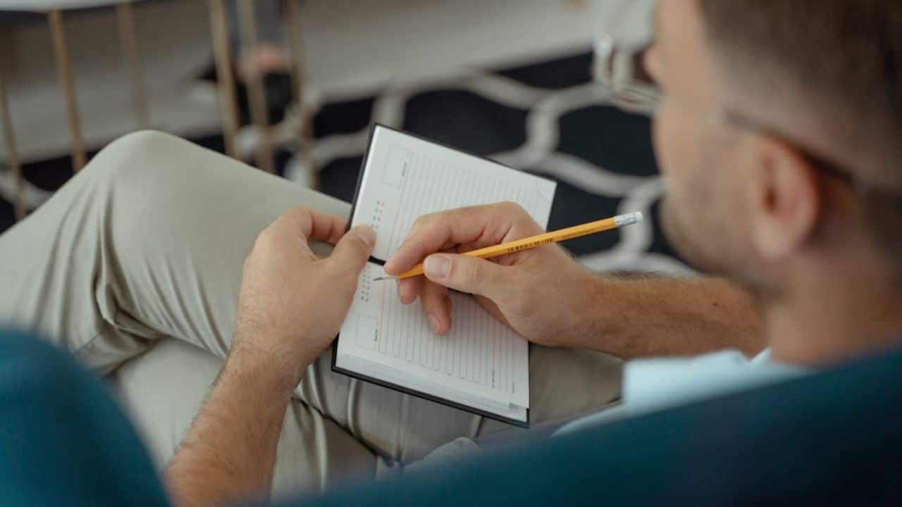 Man noting recurring signs of dishonesty over time to spot patterns, not isolated events.