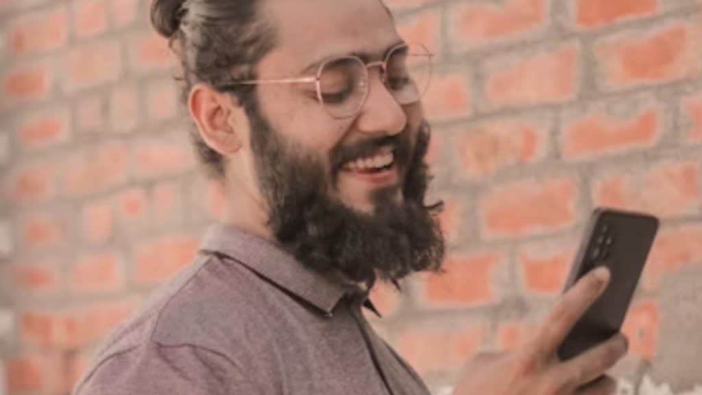 Man editing his dating app profile honestly at home on his phone.