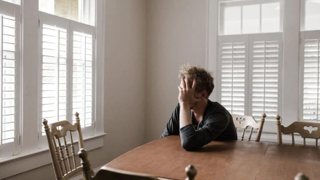 Man sitting in the dining room  preparing to express sincere accountability for his mistakes.