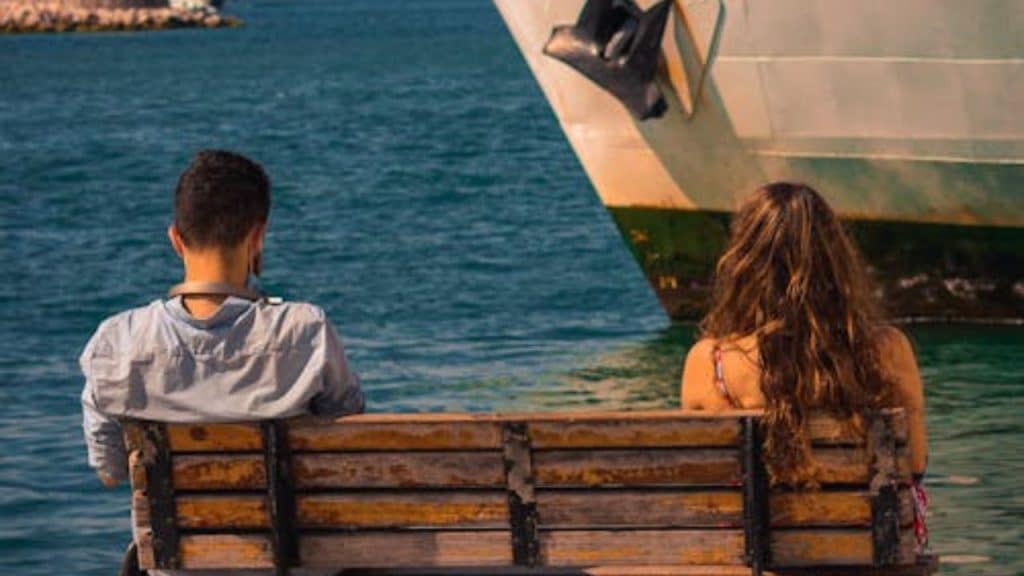 Man and a woman sitting on a bench allowing emotional distance to show respect for boundaries.