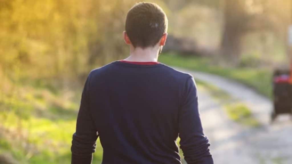 Man looking contemplative but at peace while walking alone after the rejection.