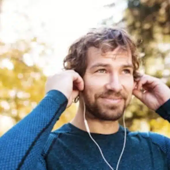 A man in his 40s walking confidently through a park at golden hour.