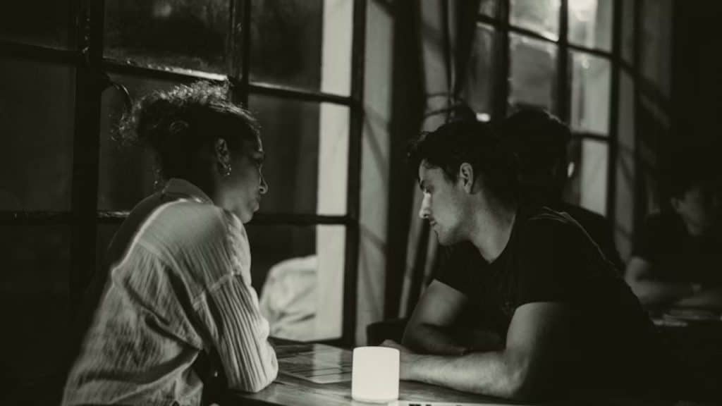 Couple resolving a disagreement calmly at a cafe.
