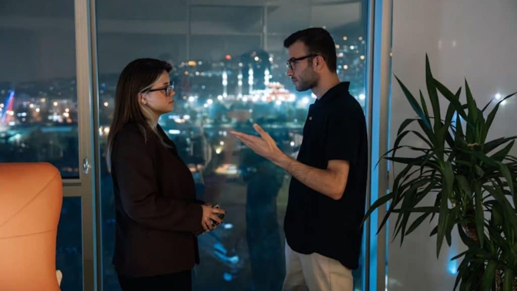 Couple calmly debriefing after a disagreement on a balcony at night.