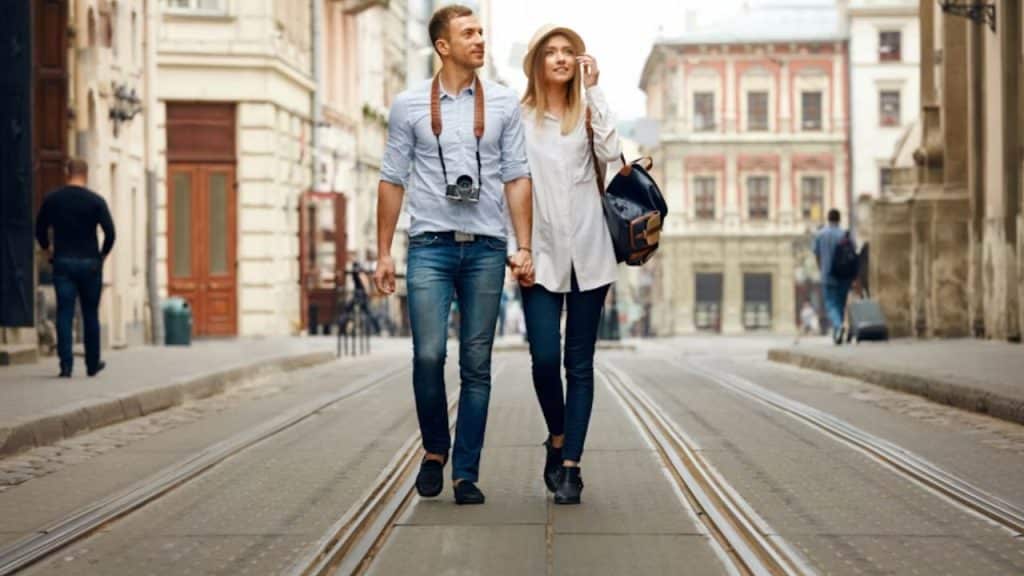 Couple walking side by side at a steady pace through a quiet city street.